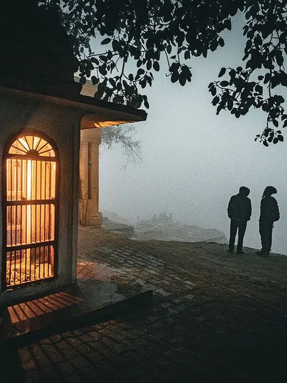 Two figures stand by the Yamuna ghat in the early morning fog, finding a moment of peace. This photograph is about atmosphere and stillness, using the soft, diffused light and minimalist composition to tell a quiet story of contemplation.