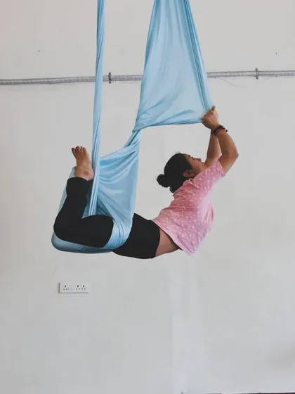 Creating different shapes is part of the joy of aerial practice. This gentle backbend, cradled by the hammock, helps to improve spinal flexibility and open the chest.