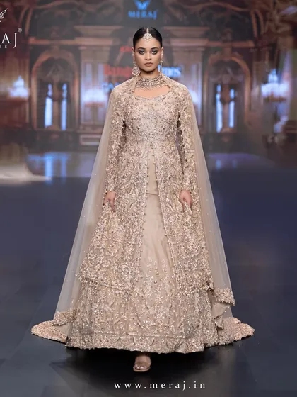 A masterpiece in gold, this tail peplum Indo-Western gown is a stunning fusion of tradition and modernity. Adorned with subtle, self-matching embellishments, it’s a sophisticated look designed for a grand wedding reception.
