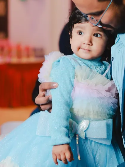 A quiet, candid moment between father and daughter amidst the party celebrations. These gentle interactions are just as important as the big, energetic moments.