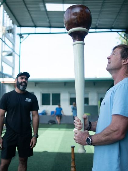 Our founder watches as an international member tries a heavy Gada for the first time. This captures the supportive and encouraging atmosphere where everyone is welcome to challenge themselves.