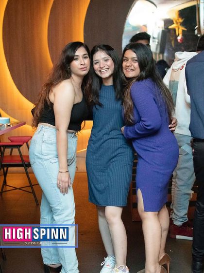 A trio of friends posing for the camera during a mid-week party.