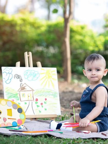 This little boy is ready to paint. Themed shoots are a fantastic way to get natural and engaging photos of your child as they explore new things.