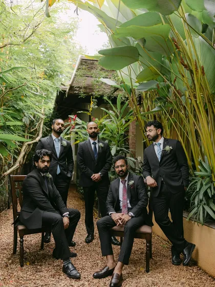 A stylishly posed portrait of the groom and his groomsmen in a lush garden setting. Their sharp suits and confident stances make for a cool and memorable group shot.
