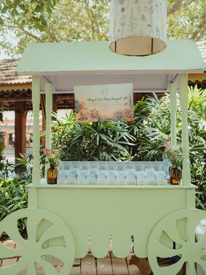 A charming cart holding hand fans for guests, with a sign that reads "Stay Cool, Stay Charged!" A thoughtful detail for a warm day.