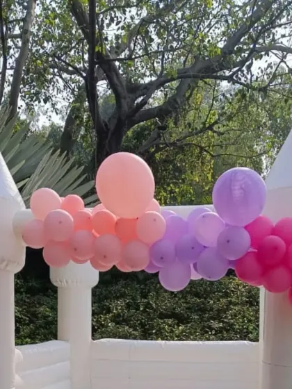 For a more elegant and stylish celebration, my all-white bouncy castle is a perfect choice. I decorate it with custom balloon garlands, like this pastel arrangement, to match your party's color scheme beautifully.