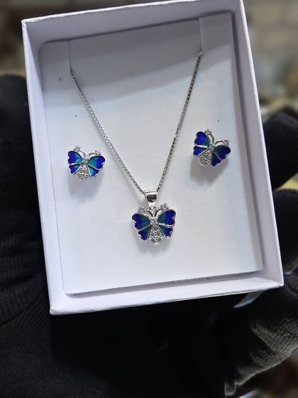 A beautiful butterfly-themed pendant and earring set in silver 925. The blue enamel work adds a vibrant touch to the design.