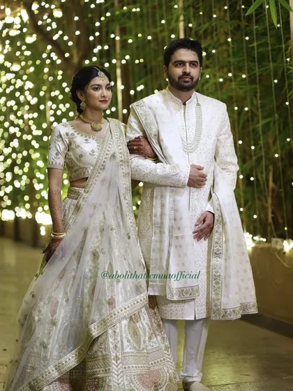 An elegant look for a ring exchange ceremony. The groom's makeup is subtle, focusing on an even skin tone and a shine-free finish that photographs beautifully, complementing his classic white sherwani.