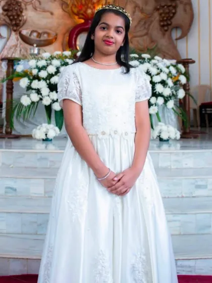 A gown for a truly special ceremony. This full-length white dress features delicate lace sleeves and embroidery, designed to be elegant and graceful for a First Communion or as a junior bridesmaid dress.