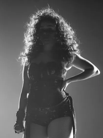 A stunning black and white portrait of Sunidhi on stage, capturing her iconic silhouette.