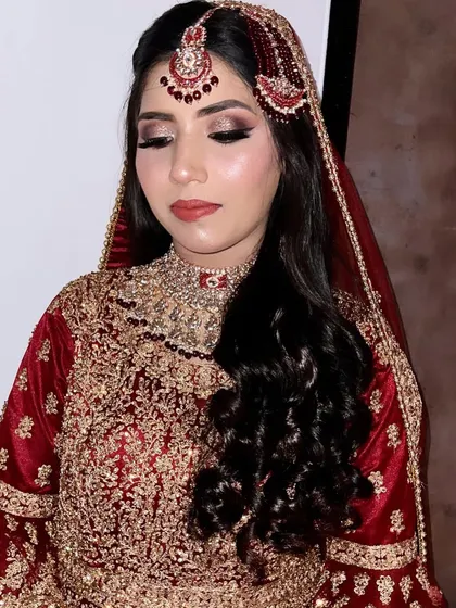 Another shot of this stunning Walima look. The makeup is designed to enhance her features and complement her beautiful red and gold outfit.