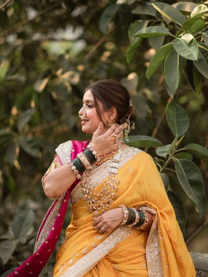 A side view of the bride's elegant updo, which perfectly complements her elaborate jewelry and the vibrant colors of her Nauvari saree.