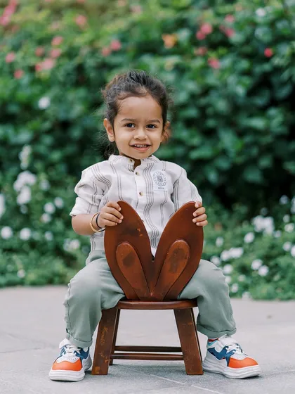 A cool and confident two-year-old boy, posing on his little bunny chair. Toddler sessions are full of fun and personality.
