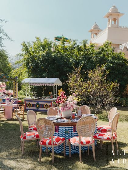 A dining setup at 'The Roots' Mehendi, with custom-printed chair cushions and tablecloths set against the palatial backdrop of Udaipur. The design was bold, expressive, and deeply personal.