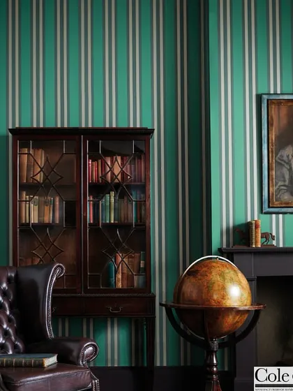 Cole & Son's classic striped wallpaper brings timeless structure and elegance to this traditional study. The bold green and white stripes create a strong vertical rhythm that enhances the room's height and formal character.