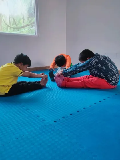 Our kids' fitness class in progress, with students focusing on their stretching routines. A strong and flexible body is the foundation of a good martial artist.