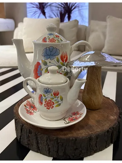 Thematic hand-painted teapots serve as centerpieces, adding an authentic touch to the tea party theme.