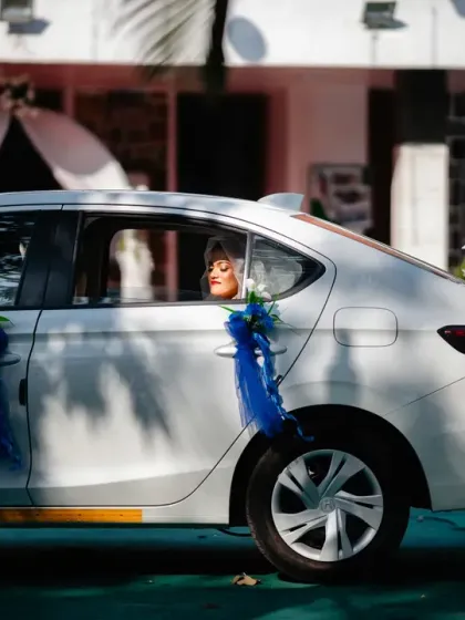The bride arrives at the church, her face beautifully lit as she looks out the car window.