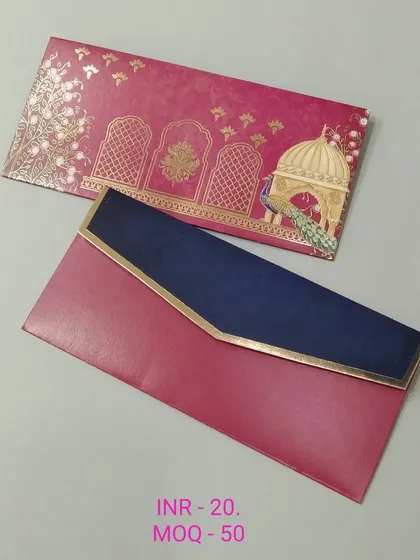 This royal-themed money envelope combines a rich magenta with a deep navy blue flap. The design includes gold foil arches, a palace dome, and a peacock, making it a luxurious choice for a shaadi.