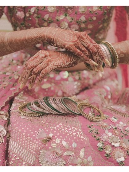 The intricate details of our bride's mehndi and bangles against her stunning pink lehenga. Every element was part of the comprehensive virtual styling plan we created for her.