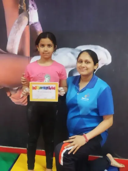 A happy student poses with her coach and her "Awesomeness" certificate, a fun award we give to celebrate great effort.