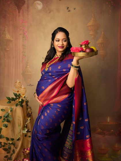 A graceful portrait of a mother-to-be holding a platter of festive offerings. The rich colors of her saree and the artistic backdrop make this a perfect Diwali memory.