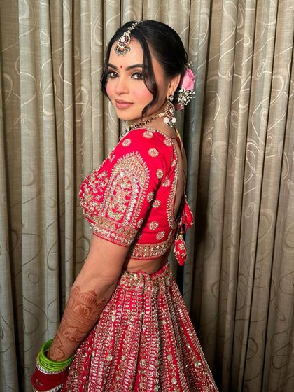 A back view of this traditional bride, showcasing the beautiful hairstyle with a fresh flower arrangement that adds a touch of elegance.