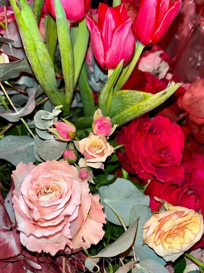 A close-up on love. This Valentine's arrangement features a mix of red tulips and different shades of pink roses, a classic and beautiful expression of romance.