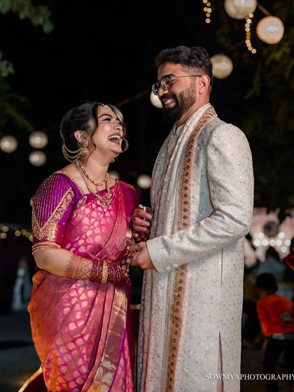 A candid moment of pure laughter between the couple during their reception. The warm lighting and their genuine smiles make this a heartwarming shot.