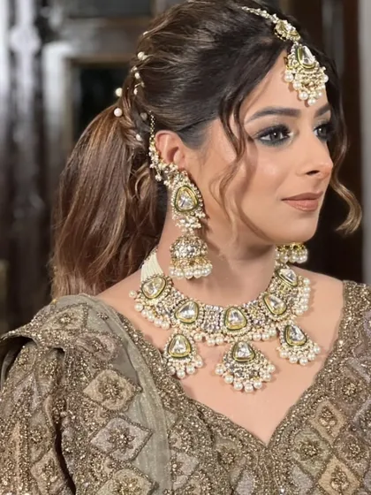 This modern Kundan and pearl set is perfect for a reception or engagement. The rental includes a necklace, oversized jhumkas, and a delicate maang tikka.
