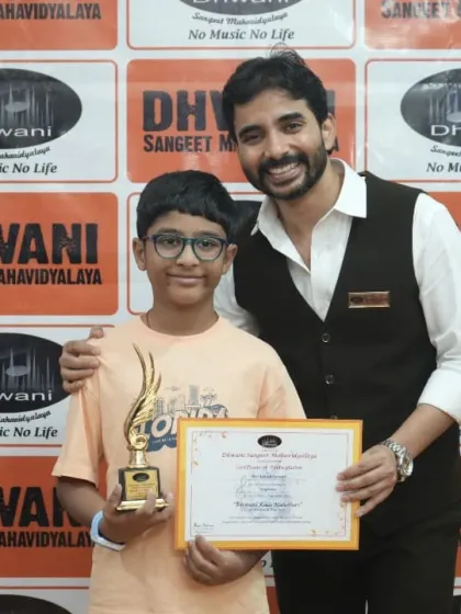 A teacher congratulates his student on winning an award for his drawing skills.