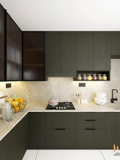 A close-up of the cooking area in the dark green kitchen, showing the open spice rack and under-cabinet lighting.
