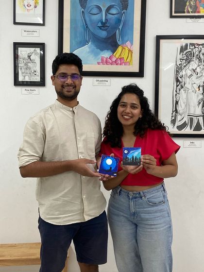 A couple proudly holds up the miniature canvas paintings they created. My workshops are a great way to spend quality time and do something different.
