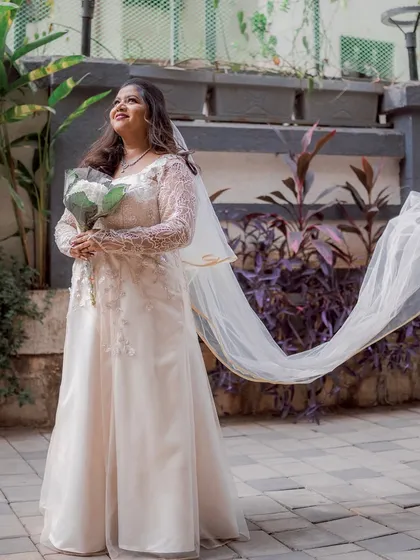 A full-length shot of the bride, her veil flowing gracefully in the breeze.