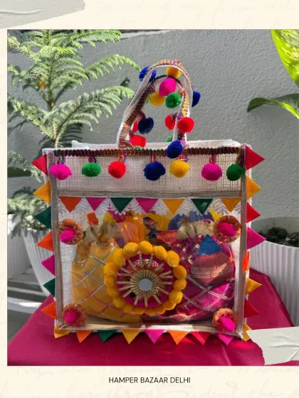 A clear shot of our colorful and festive Jute Bag Holi Hamper. The pom poms and bright colors make it a super fun gift to carry to a Holi party.