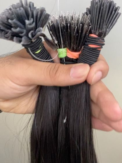 A hand holding three different types of permanent extensions: U-Tip, I-Tip, and Nano-Tip, showcasing our diverse product range.