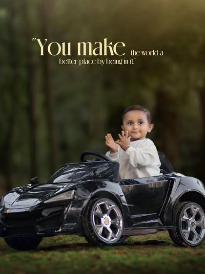 You make the world a better place by being in it. A happy toddler claps his hands with joy while sitting in his toy car.