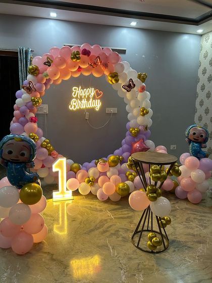 This angle of the pastel Cocomelon decor shows the butterfly accents and the mix of gold and pastel balloons.