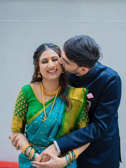 A playful and affectionate kiss on the cheek. This candid shot is full of joy and captures the pure happiness of their engagement day.