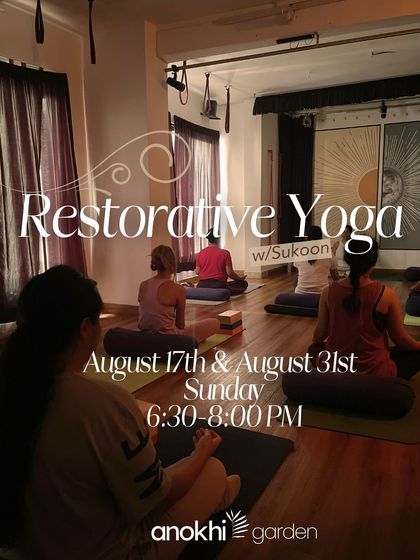 Participants settle into a Restorative Yoga session, supported by bolsters and blankets. This practice is about intentional rest, inviting the nervous system to unwind and the body to heal.