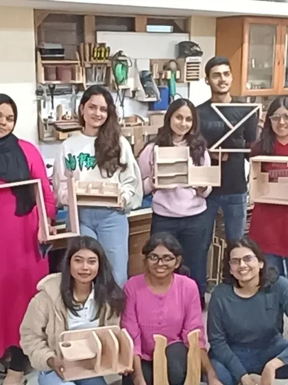 A group of interior design students with the amazing variety of projects they created in a one-day workshop, from chairs to complex organizers.