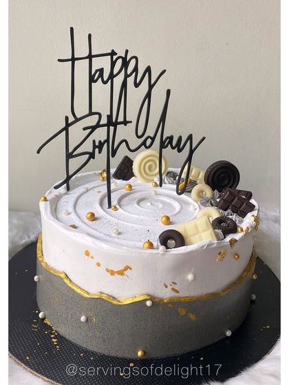 A sophisticated black, white, and grey cake with gold accents. This design is perfect for a milestone birthday or a formal event.