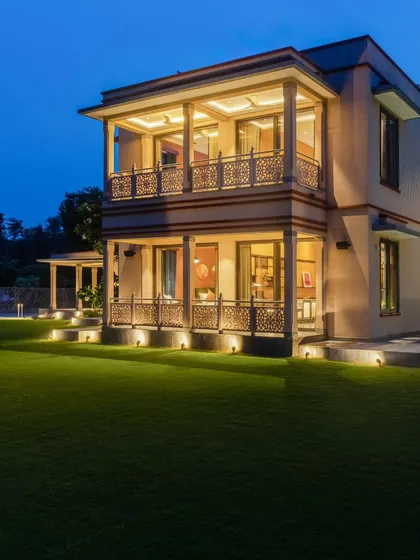 This view shows how layered lighting can create depth and beauty. The ground lights, balcony lights, and interior lights are all part of an integrated system, creating a warm and inviting look for the entire property.