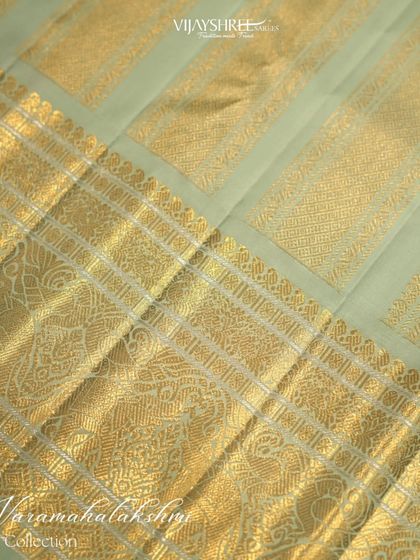 The rich gold zari border on the contrasting blue-green pallu.