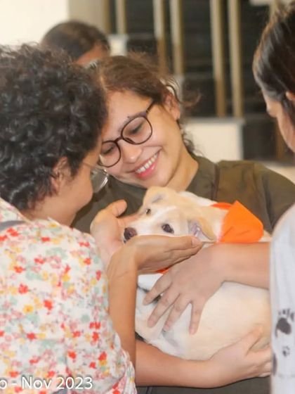 A happy moment captured at our Atta Galatta adoption camp. A volunteer shares a cuddle with a puppy, showing our love for all animals.