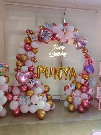 Another angle of the "PUNYA" birthday setup, showing the full balloon arch and personalized elements.