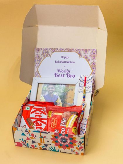 This Rakhi gift box is filled with sweet treats like KitKat and Choco Pie, along with a personalized photo frame and a 'World's Best Bro' card.