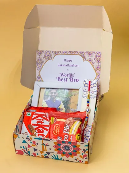 This Rakhi gift box is filled with sweet treats like KitKat and Choco Pie, along with a personalized photo frame and a 'World's Best Bro' card.