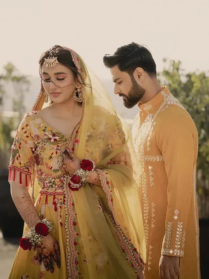 Another romantic shot of the couple. The bride's floral jewellery and the groom's mirror-work kurta are perfect for a sun-drenched pre-wedding event.