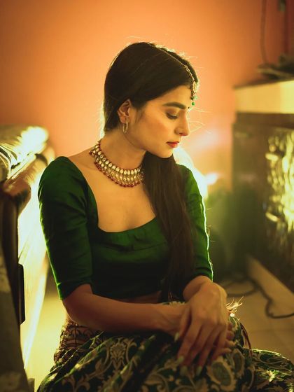 An introspective portrait from an editorial shoot. The soft, warm lighting and the downward gaze of the model create a quiet, story-driven image with a vintage film aesthetic.